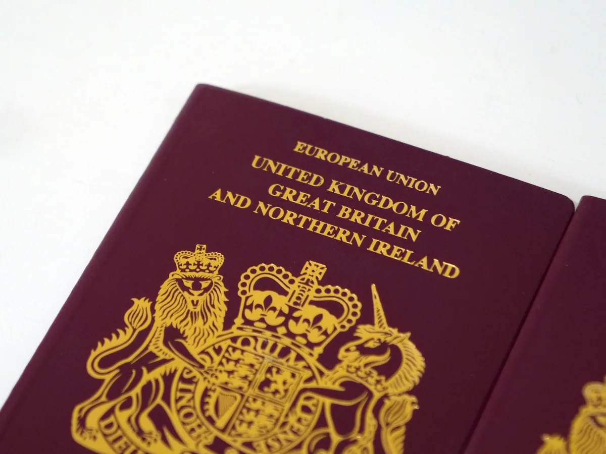 Burgundy United Kingdom passport on a white table
