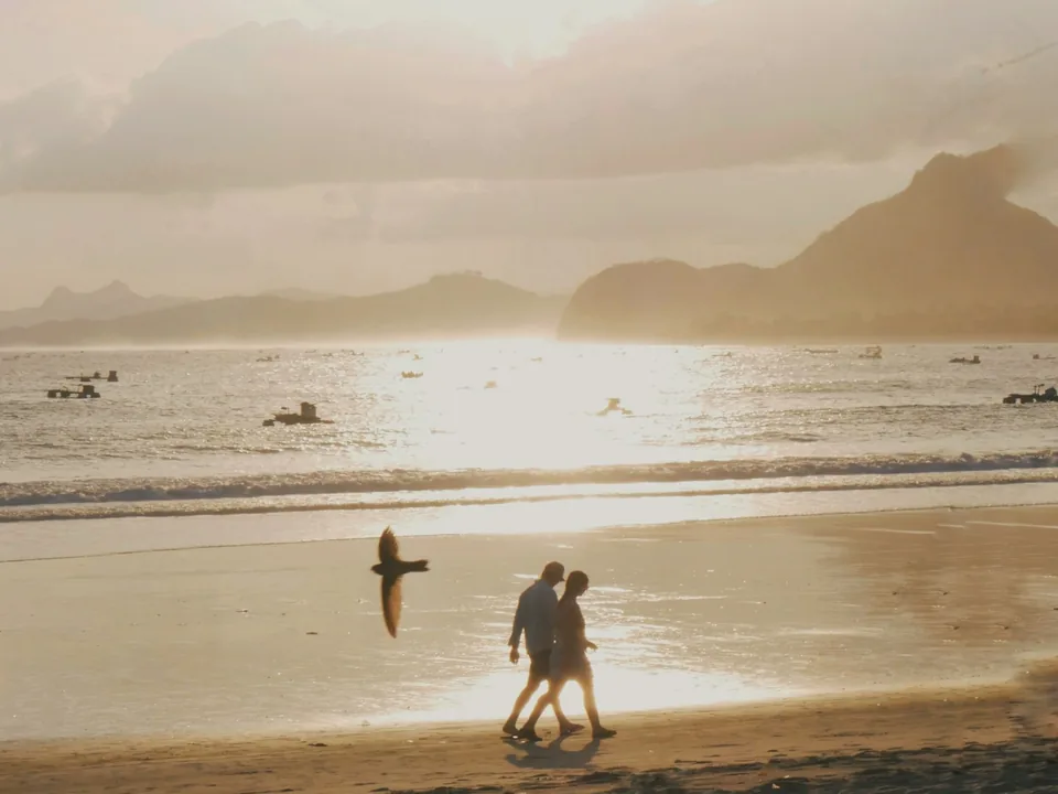 Couple walking along a Bali beach at sunset
