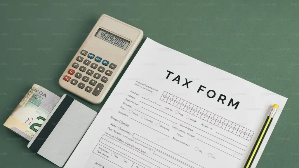 A tax return form beside a calculator and pen, representing HMRC and Indonesian tax obligations