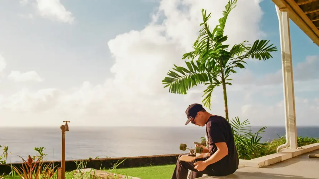 A man working from a porch overlooking the ocean in the tropics, remote working from Bali