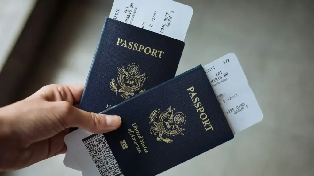 A hand holding passports with airline boarding passes tucked inside, ready for travel to Bali