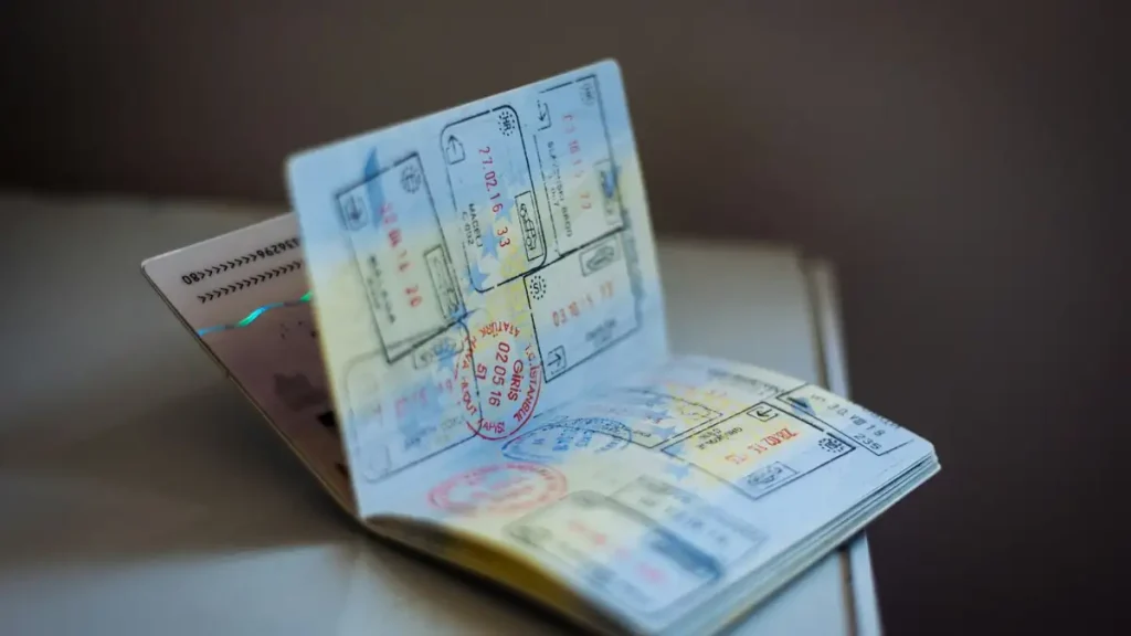 An open passport covered in immigration ink stamps, showing different visa types