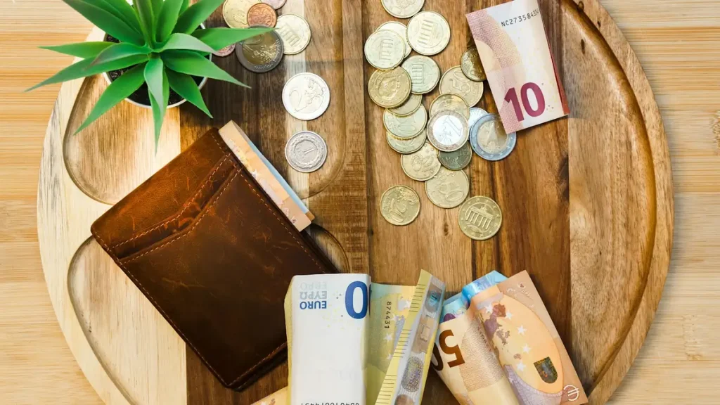 Banknotes spread across a wooden table, budgeting the Bali entry levy for 2027