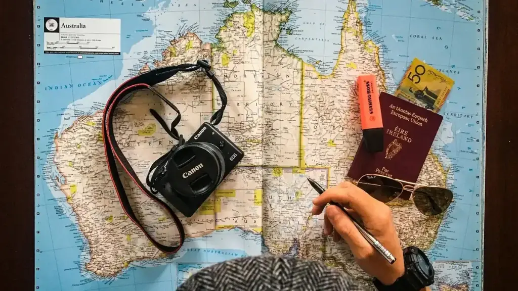 A flat lay of a pen and notes over a world map, planning a 2027 Bali trip budget